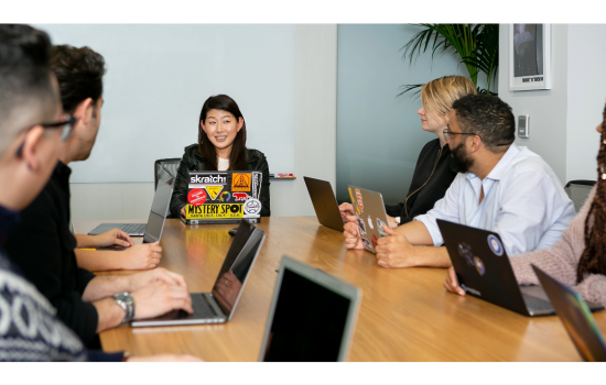 A business meeting with the individuals using laptops for viewing a shared presentation.