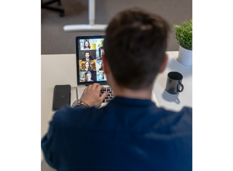 Individual on a virtual meeting using a laptop.