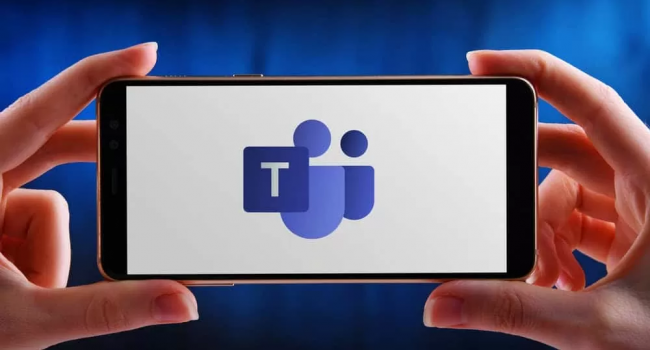 Phone being held horizontally with the logo of Microsoft Teams being shown.